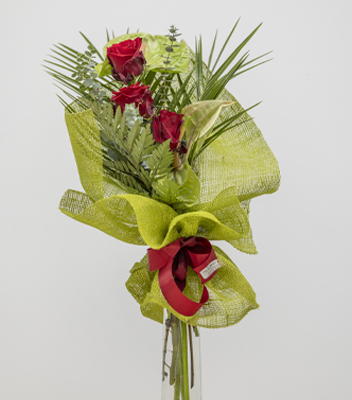 Boquet di rose rosse composto da 3 rose rosse, qualche fiore di anturium e delle foglie verdi. Il bouquet si sviluppa in altezza ed è avvolto in una confezione verde chiaro con un fiocco rosso della stessa tonalità delle rose