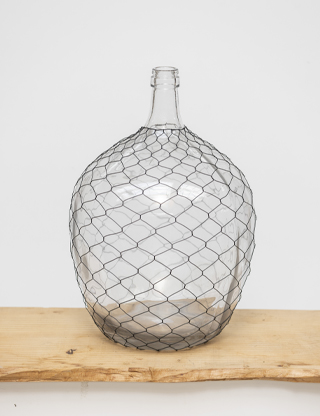vasoVetro+rete Grande vaso in vetro trasparente avvolto in una rete metallica decorativa, perfetto per arredamenti dallo stile rustico o industrial.