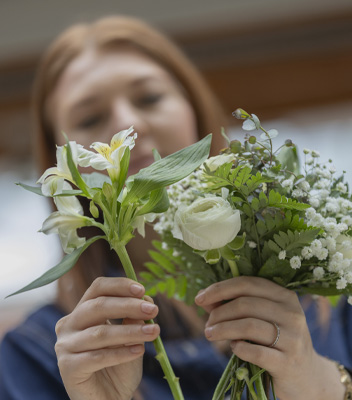 Anna, la figlia di Roberto Tomasi, sta creando un bouquet estivo con fiori bianchi da Vivai Tomasi